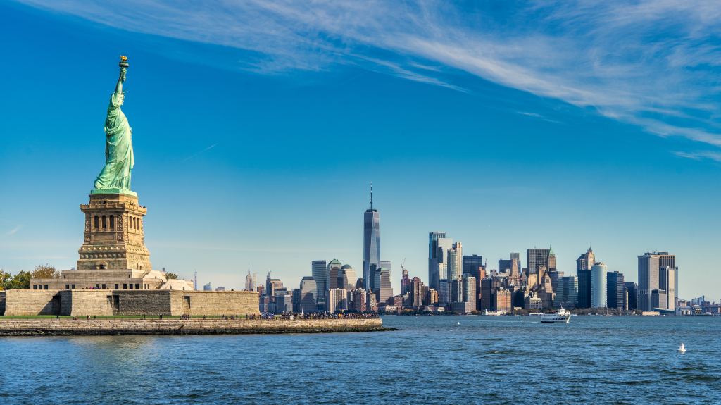 A photo of the Statue of Liberty and in the backdrop is lower Manhattan.